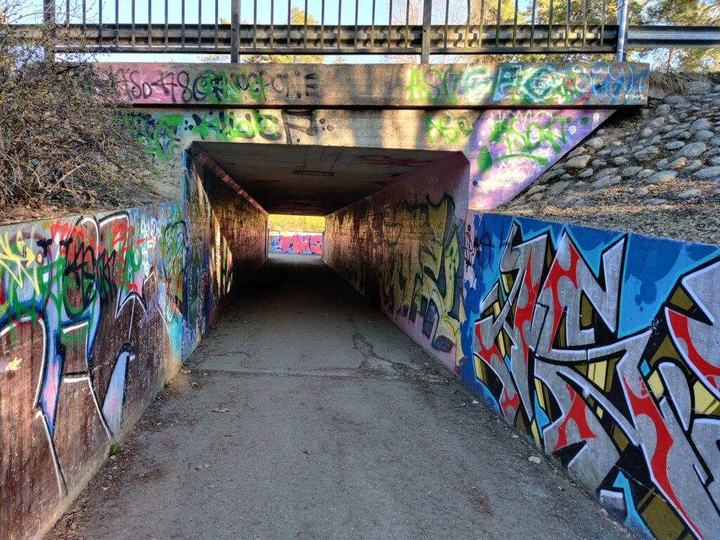 Betoninen alikulkutunneli, jonka seinissä on värikkäitä graffiteja.